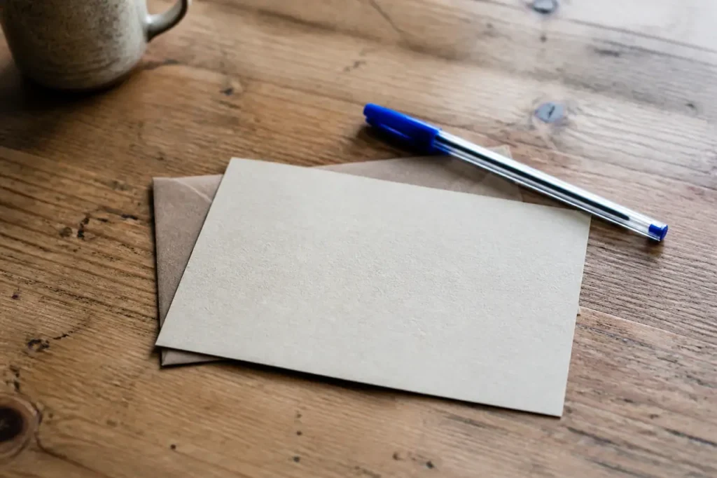 Carte manuscrite sur table en bois avec stylo bleu