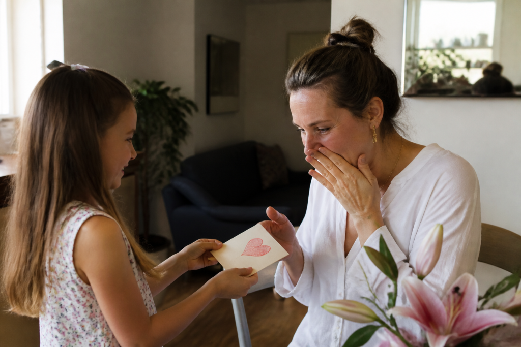 Fille offrant une carte manuscrite a sa mere